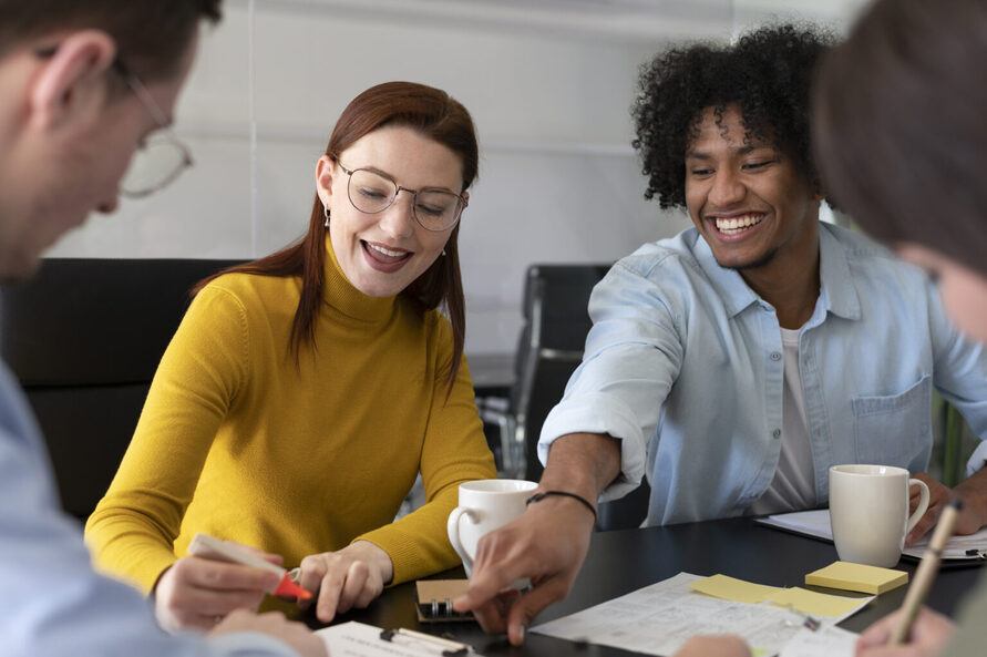 Colaboradores em uma mesa conversando sobre a jornada do colaborador