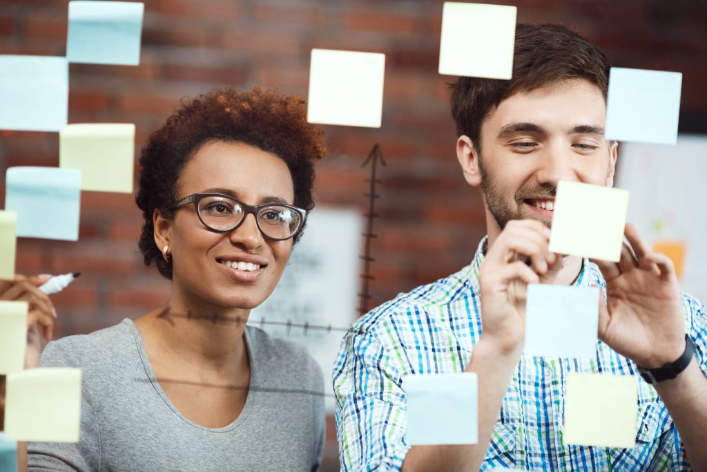 Colegas de trabalho sorrindo - imagem por Freepik | Dia do Trabalho: trabalhando com propósito - artigo por talent academy